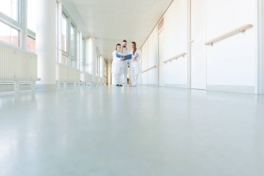 Hastane koridorunda üç doktor kısa bir toplantı yapıyor.