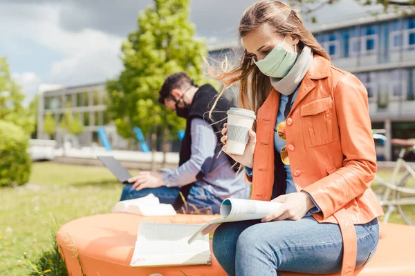 Kobieta student na kampusie studenckim uczy się nosić maskę twarzy — Zdjęcie stockowe