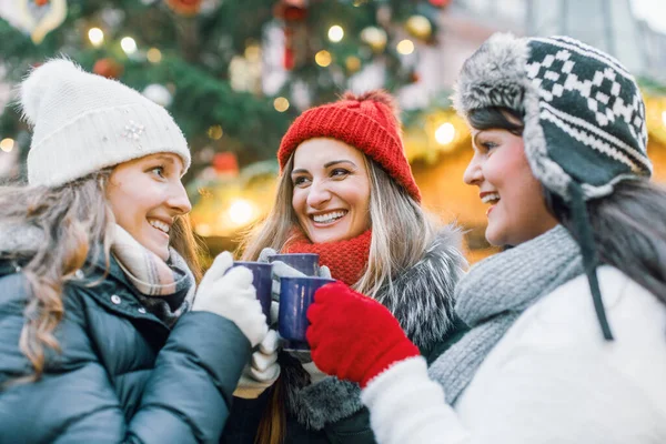 Mercado de Navidad para un grupo de amigas bebiendo vino caliente caliente con especias — Foto de Stock