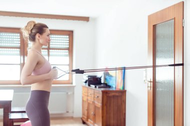 Güzel bir kadın karantina sırasında evde spor yaparken formda kalıyor.