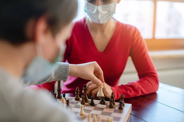 Family playing board games during curfew moving chess pieces