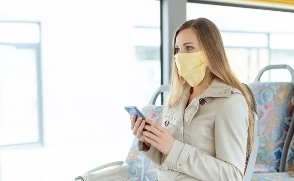 Wanita yang menggunakan telepon di bus mengenakan masker wajah — Stok Foto