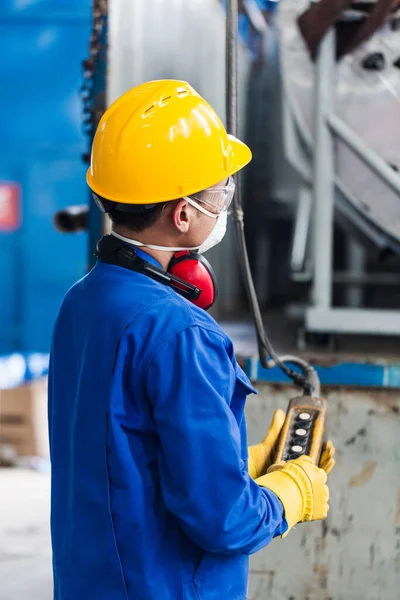 Habilitado trabalhador asiático controlando gancho industrial — Fotografia de Stock