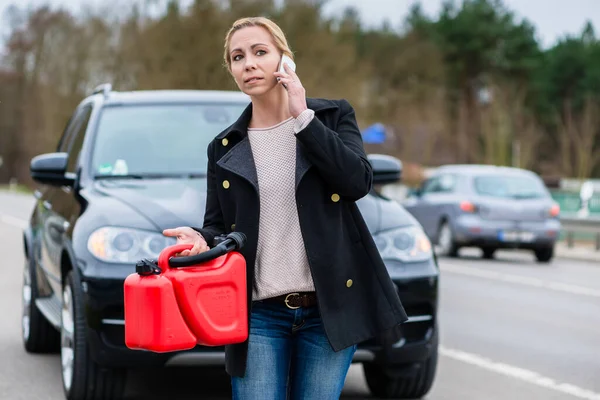 Žena má auto s prázdnou nádrží volající o pomoc na telefonu — Stock fotografie