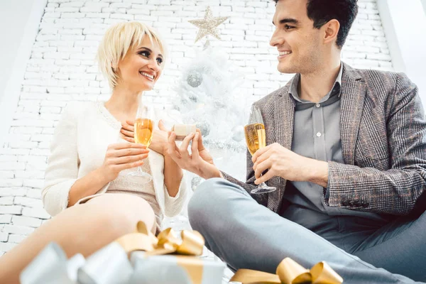 Mujer y hombre con vino y regalos delante del árbol de Navidad blanco —  Fotos de Stock
