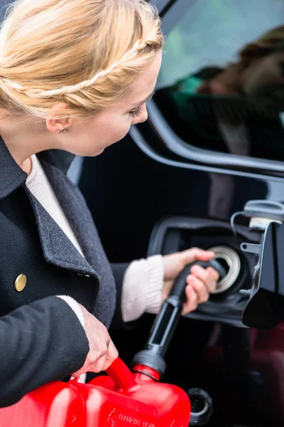 Mujer llenando el coche con gasolina de la lata de repuesto — Foto de Stock