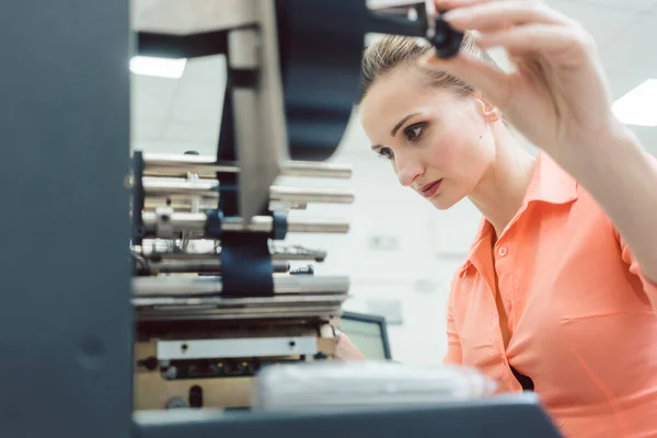 Mujer trabajadora poniendo nuevas etiquetas en la máquina de impresión —  Fotos de Stock