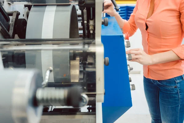 Mulher pressionando o botão Iniciar na máquina de impressão de etiquetas — Fotografia de Stock
