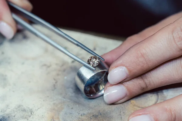 Joyero colocando una piedra preciosa con pinzas en un anillo —  Fotos de Stock