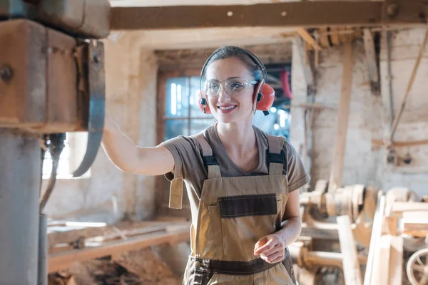 Carpintero mujer en carpintería tradicional ajustando la cepilladora de la máquina —  Fotos de Stock