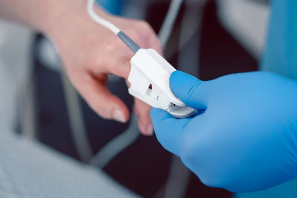 Asistentă medicală în spital care pune senzor de tensiune arterială pe degetul pacienților — Fotografie, imagine de stoc