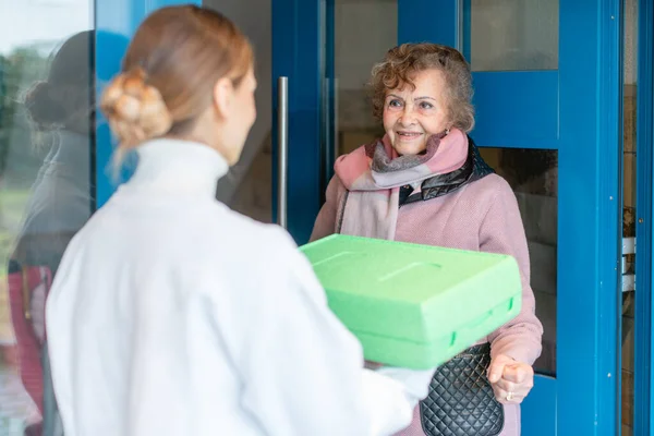 Vrijwilliger leveren van een maaltijd aan de deur van senioren — Stockfoto