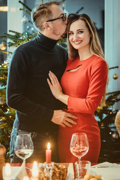 Pareja de mediana edad en pose romántica frente al árbol de Navidad — Foto de Stock