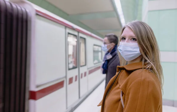 Tren gelirken toplu taşıma araçlarındaki insanlar maske takıyor. — Stok fotoğraf