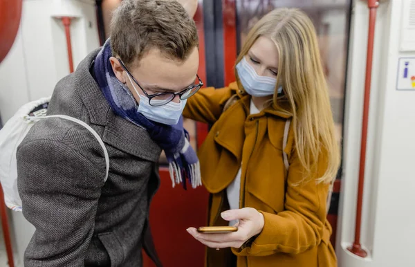 Persone che utilizzano il telefono in treno indossando covid-19 maschera — Foto Stock