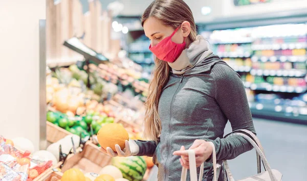 Женщина делает покупки в супермаркете во время блокировки коронавируса — стоковое фото