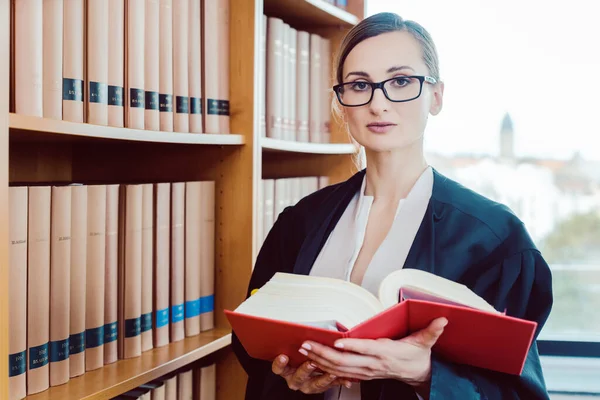 Právník pracuje na obtížném čtení případů v knihovně — Stock fotografie