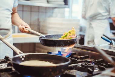 Aşçı bir restoranda yemek pişiriyor.