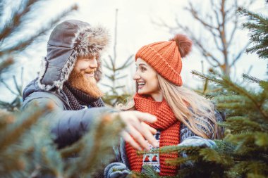 Kadın ve erkek marketten Noel ağacı alıyorlar.