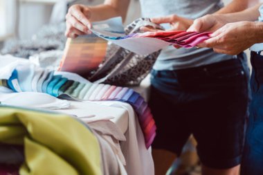 Stüdyo masasında eller kumaş desenli palette.