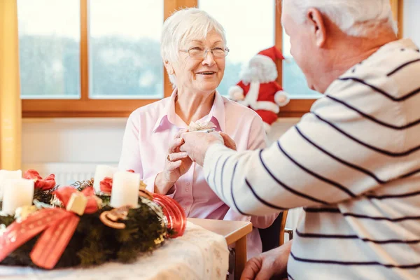 Seniorer på plejehjem udveksler gaver til jul - Stock-foto
