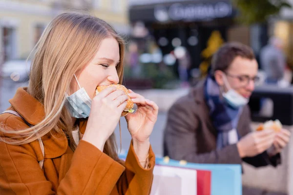 Casal comer fast food ao ar livre durante o desligamento — Fotografia de Stock
