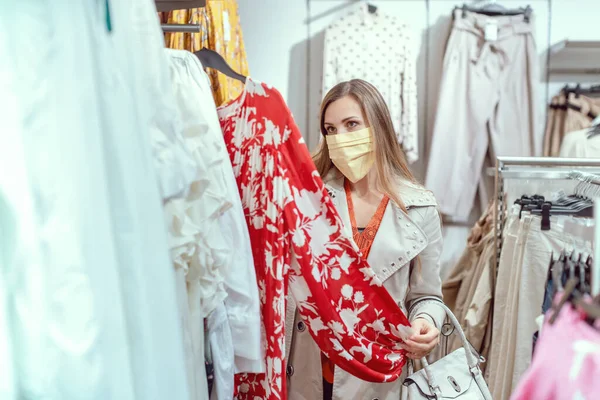 Woman shopping in fashion store wearing face mask