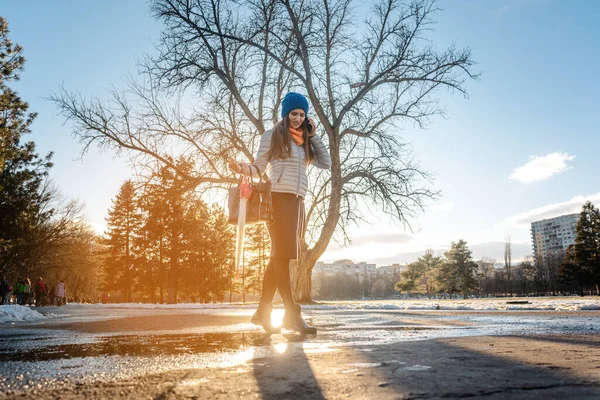 水の水たまりに足を踏み入れて雪を投げ込む女 — ストック写真