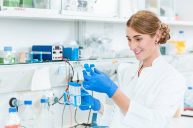 Araştırma görevlisi test tüplerine bakıyor.