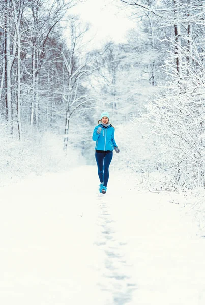 Mujer corriendo hacia la cámara en el bosque frío y nevado — Foto de Stock