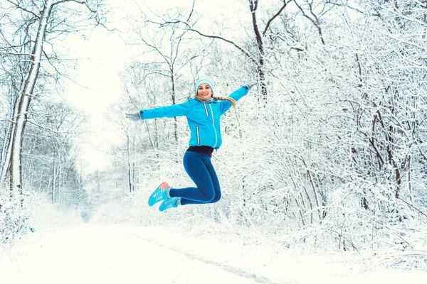 Spor elbiseli neşeli kadın kışın ve karın tadını çıkarıyor. — Stok fotoğraf