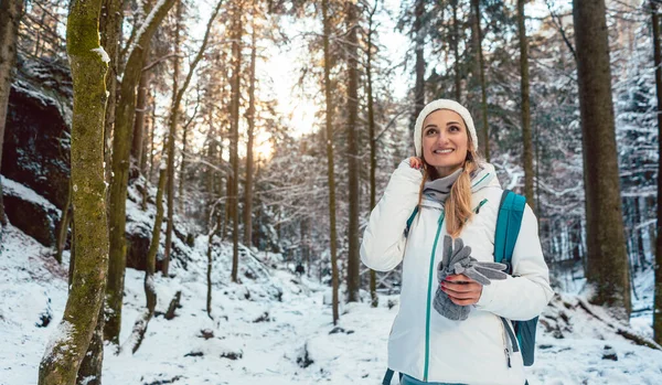 Kadın kış yürüyüşünde Ormanda günbatımının tadını çıkarıyor — Stok fotoğraf