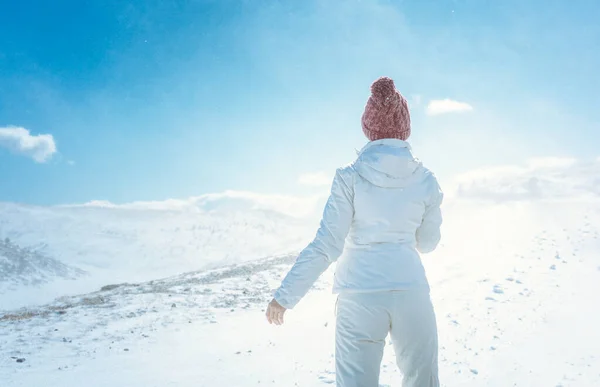 Egy nő nézi az első havat a hegyekben. — Stock Fotó