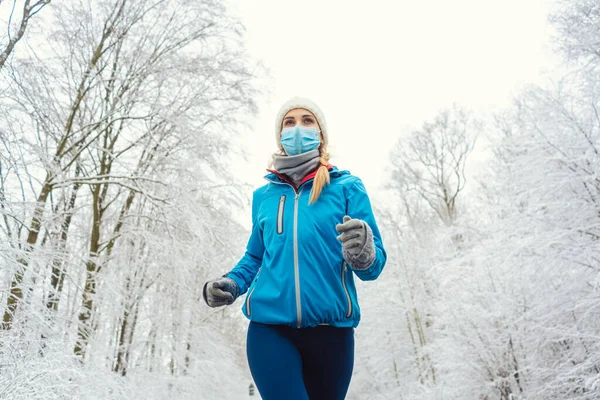 Mulher correndo ou correndo com máscara facial no inverno covid-19 — Fotografia de Stock