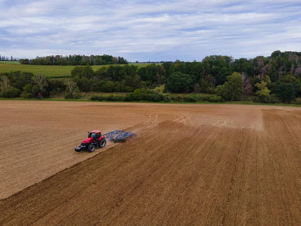 Agricultor con tractor en campo ancho labrando el suelo — Foto de Stock