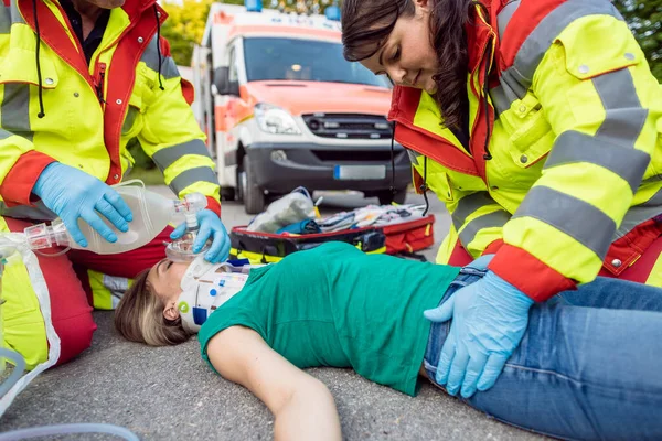 Acil servis doktoru motosiklet kazasından sonra yaralı kadını havalandırıyor. — Stok fotoğraf