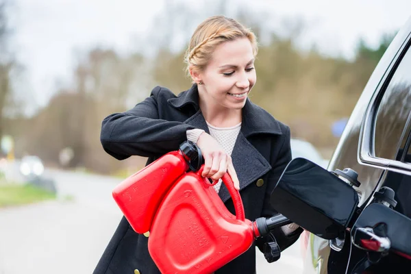 Mujer llenando el coche con gasolina de la lata de repuesto — Foto de Stock