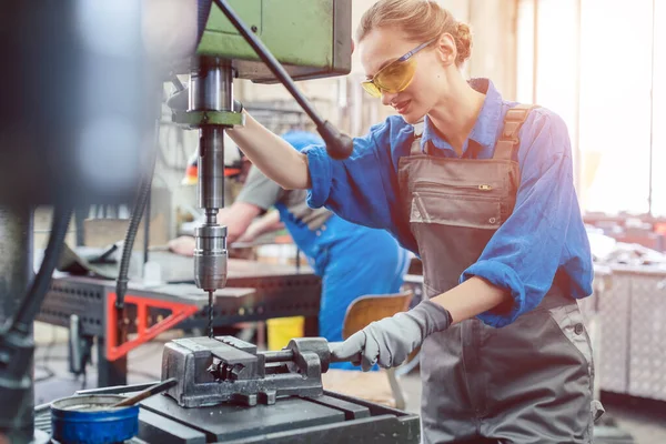 Trabajadora metalúrgica operando máquina de perforación — Foto de Stock