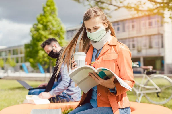 Kobieta student na kampusie studenckim uczy się nosić maskę twarzy — Zdjęcie stockowe