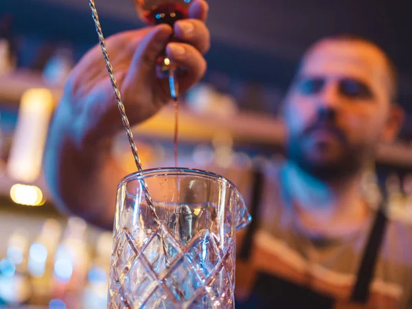 Barman wlewa alkohol do pustej szklanki, żeby zrobić drinka w pubie. — Zdjęcie stockowe