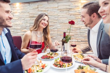 Arkadaşlar lüks restoranda atmosfer, yiyecek ve içeceğin tadını çıkarıyorlar.