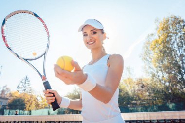 Güzel bir kadın tenis oynamaya hazırlanıyor.