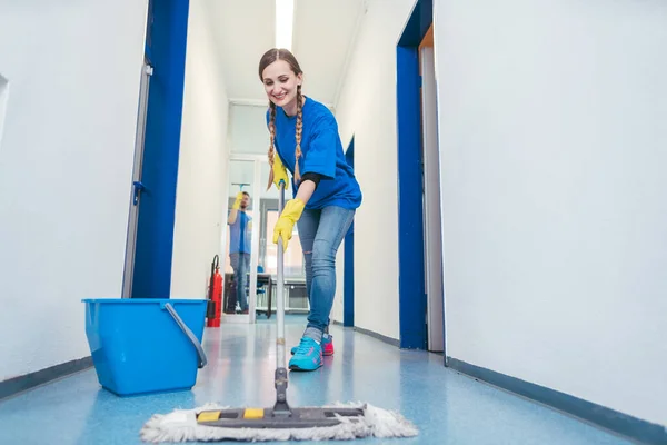 Cleaning lady mopping the floor in an office building — Stock Photo, Image