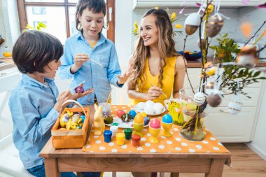 Anne ve oğulları Paskalya için yumurta boyuyor.