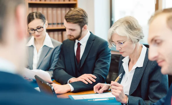 Equipe de sócios em um escritório de advocacia trabalhando diligentemente em um caso — Fotografia de Stock