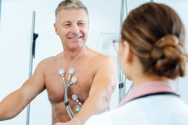 Hastanın stres EKG sonuçlarıyla ilgili tartışan doktor.