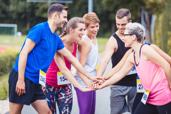 Grupo de corredores de maratón apilando manos — Foto de Stock