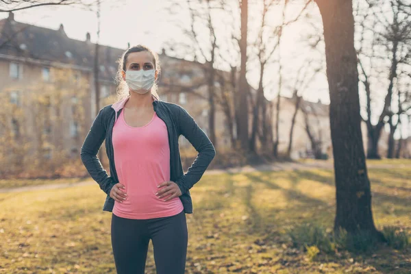 Mujer en forma durante crisis de salud haciendo ejercicio al aire libre usando máscara — Foto de Stock