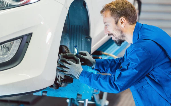 Auto mechanic servicing car in the workshop — Stock Photo, Image