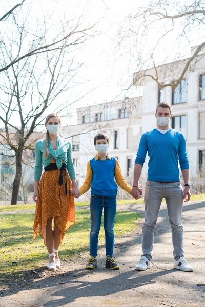 A család, akik a napon sétálnak a koronavírus vészhelyzet idején — Stock Fotó